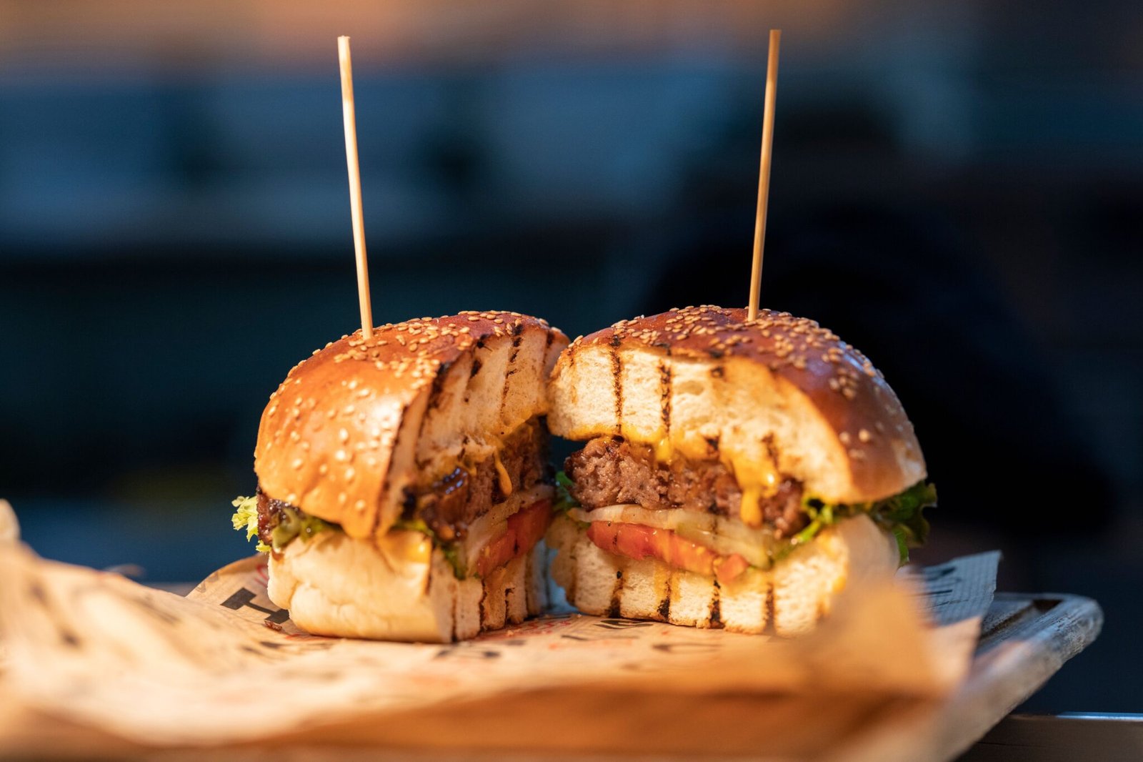 Close-up of a gourmet burger sliced in half, showcasing fresh ingredients and juicy details.